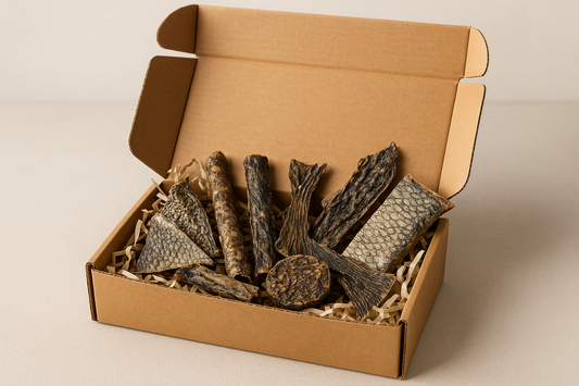 a box of mixed fish natural dog treats. regular looking postal box with treats inside on a shredded paper bed